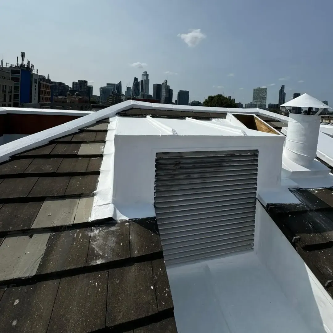 A louvre vent and surrounding upstands sealed white, with the City of London skyline beyond