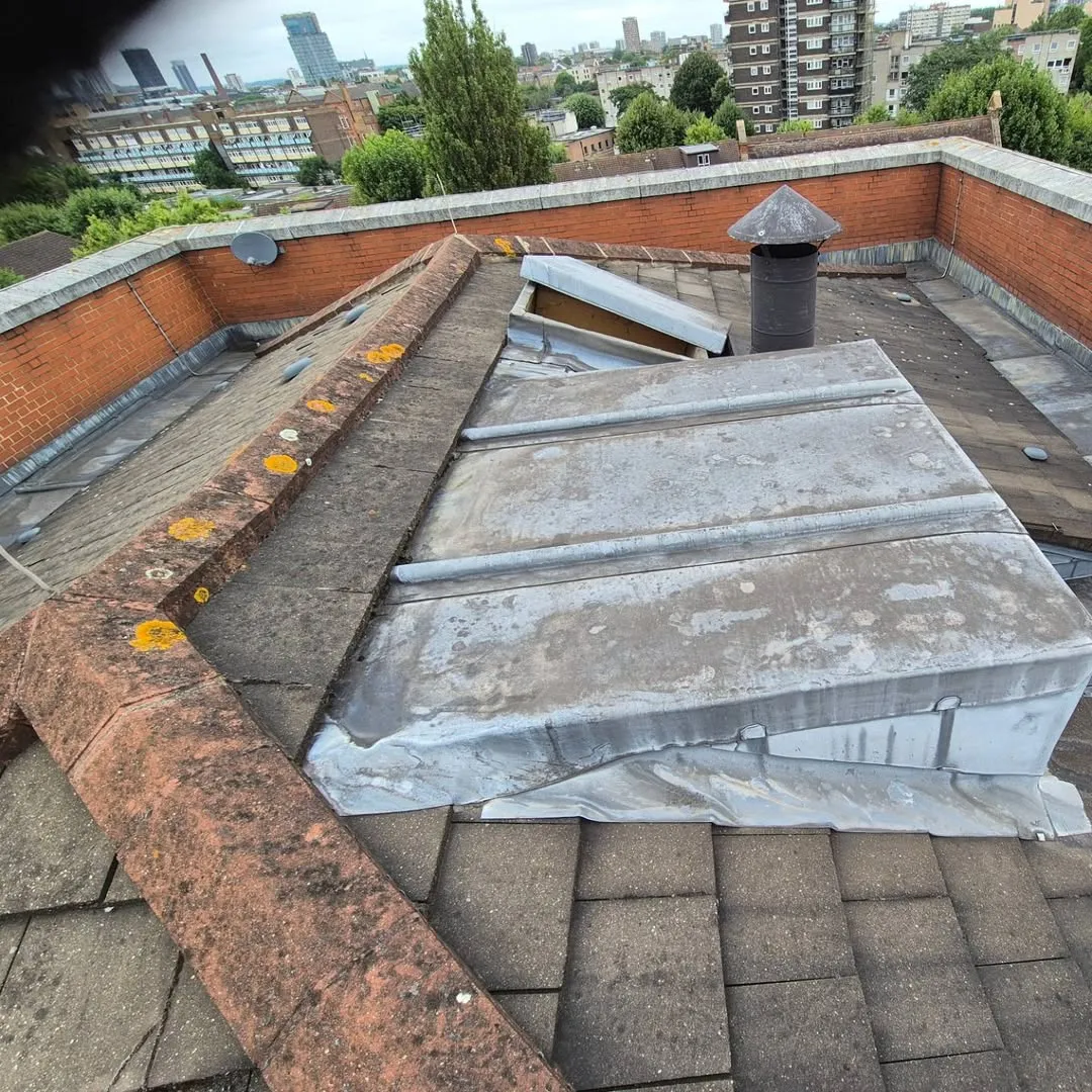 Weathered lead cladding and a worn parapet coping before refurbishment